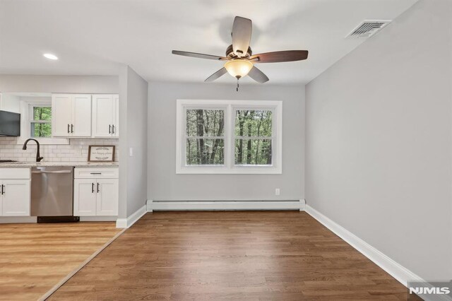 kitchen featuring visible vents, decorative backsplash, white cabinets, a baseboard radiator, and dishwasher