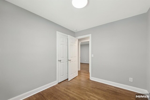 unfurnished bedroom with baseboards and wood finished floors