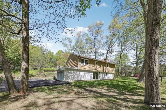 rear view of property featuring a lawn and a chimney
