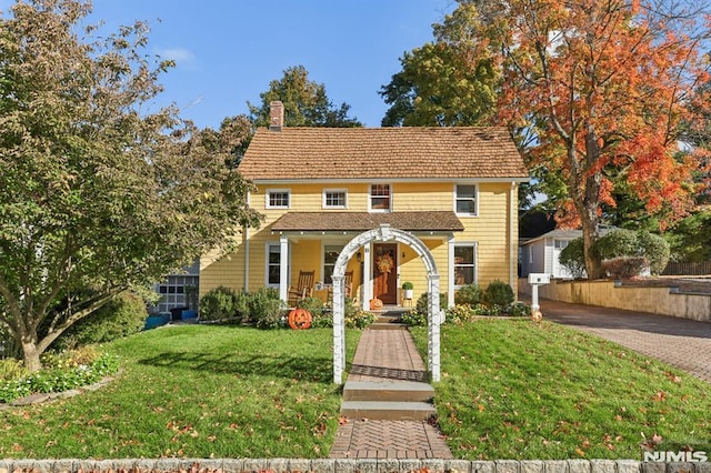 colonial house with a chimney and a front lawn