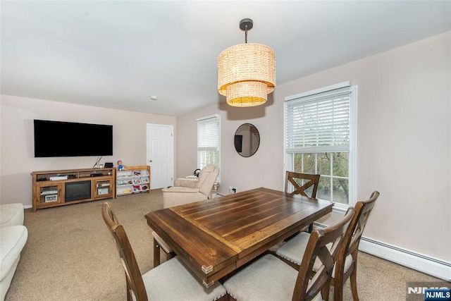 dining space featuring carpet floors, a notable chandelier, and a baseboard heating unit