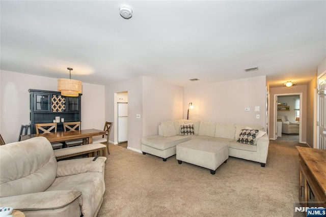 living area featuring light carpet and visible vents