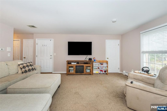 carpeted living room with a baseboard heating unit, baseboards, and visible vents