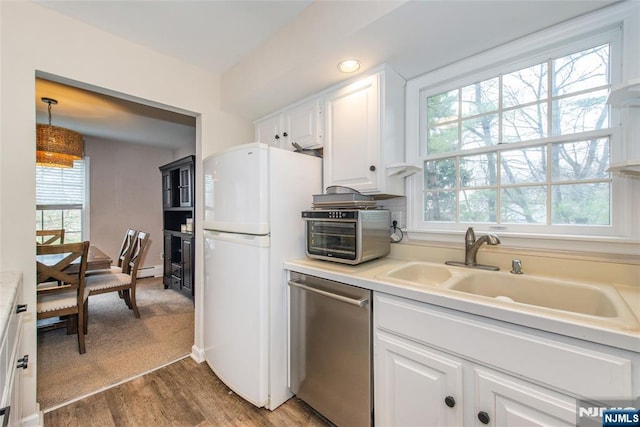 kitchen with a toaster, white cabinetry, freestanding refrigerator, dishwasher, and a sink