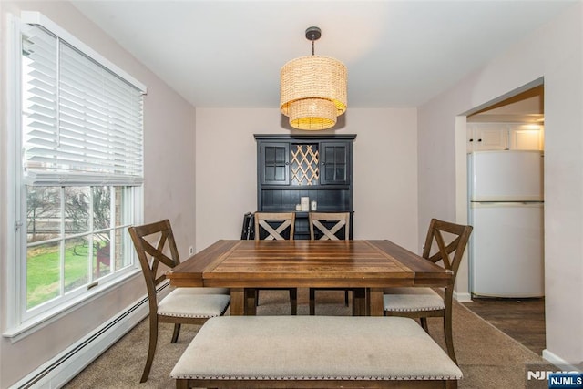 dining room featuring a baseboard heating unit and baseboards