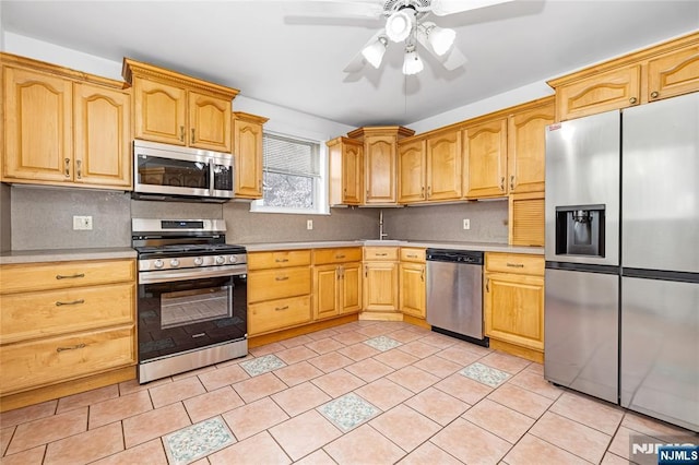 kitchen with a ceiling fan, decorative backsplash, appliances with stainless steel finishes, and light countertops