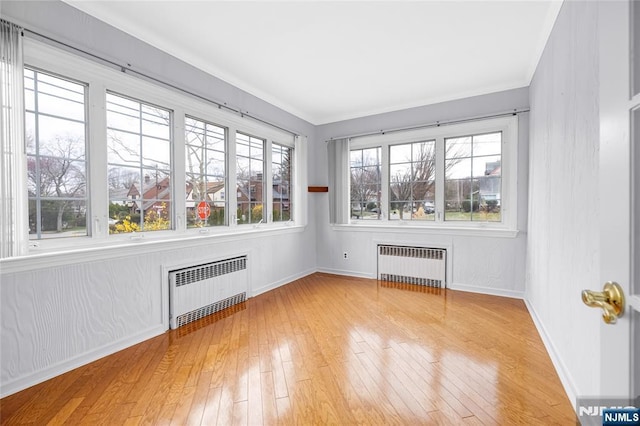 interior space with baseboards, radiator heating unit, and hardwood / wood-style flooring
