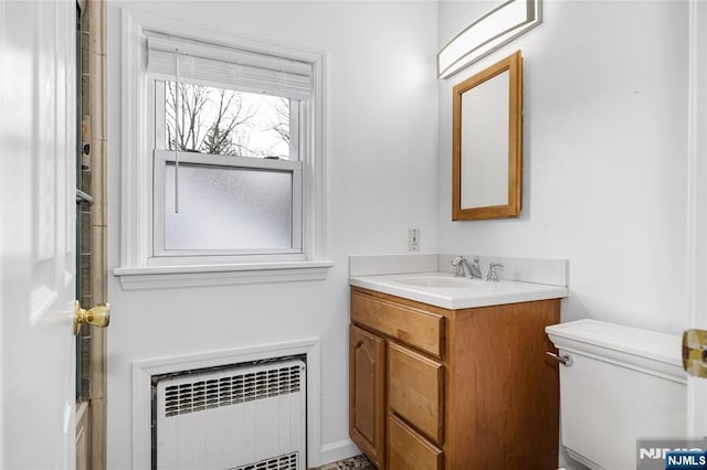 bathroom featuring radiator heating unit, vanity, and toilet