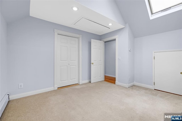 additional living space featuring attic access, recessed lighting, vaulted ceiling with skylight, baseboard heating, and carpet floors