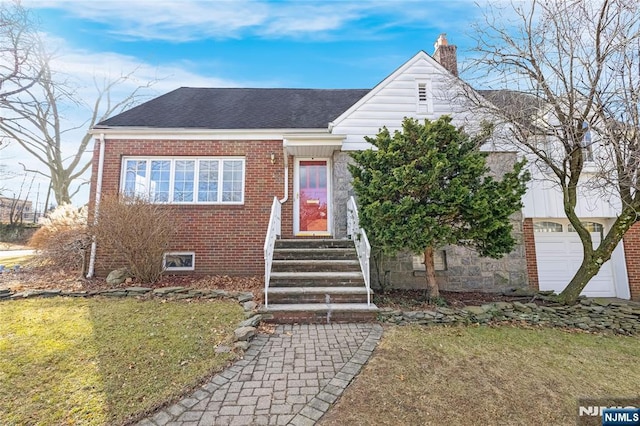 view of front of home featuring a chimney, a front lawn, entry steps, roof with shingles, and brick siding