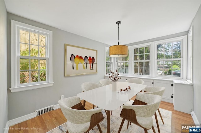 dining area featuring light wood-type flooring and baseboards