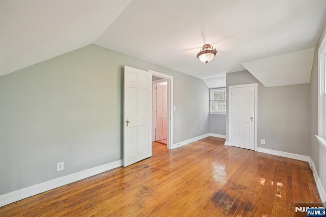 bonus room featuring vaulted ceiling, baseboards, and hardwood / wood-style floors