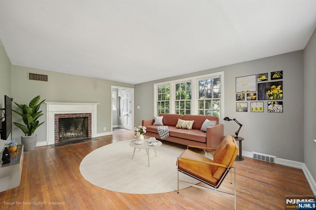 living room with baseboards, a fireplace, and wood finished floors