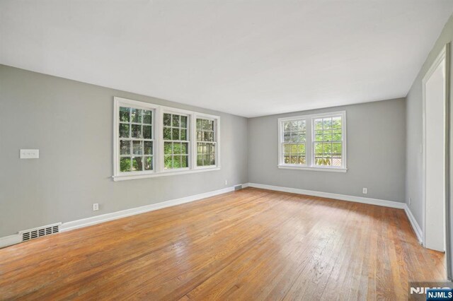 unfurnished room featuring baseboards and light wood-style floors