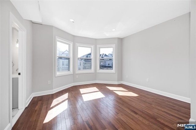 empty room with recessed lighting, hardwood / wood-style flooring, and baseboards
