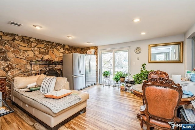 living area featuring visible vents, light wood finished floors, and recessed lighting