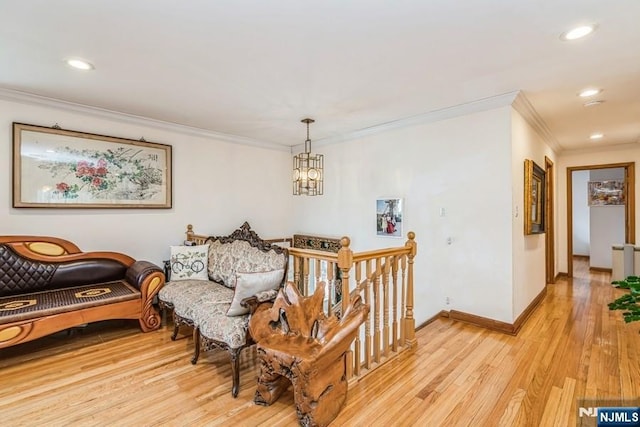 interior space with light wood-style floors, an inviting chandelier, baseboards, and ornamental molding