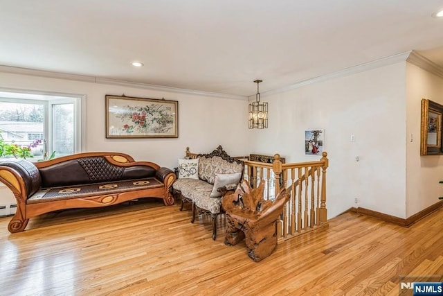 sitting room featuring baseboards, an inviting chandelier, ornamental molding, an upstairs landing, and light wood-style floors