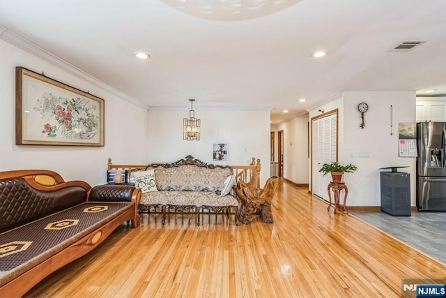 living area with visible vents, a notable chandelier, ornamental molding, recessed lighting, and wood-type flooring
