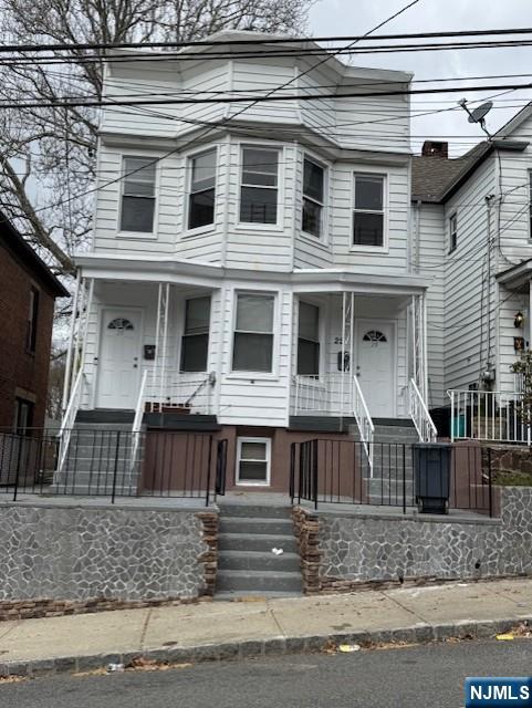 view of front of home featuring a porch and fence