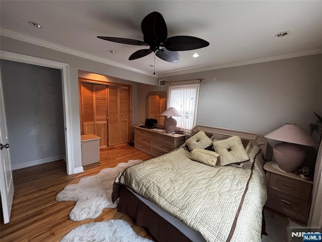 bedroom featuring a closet, baseboards, a ceiling fan, crown molding, and light wood finished floors