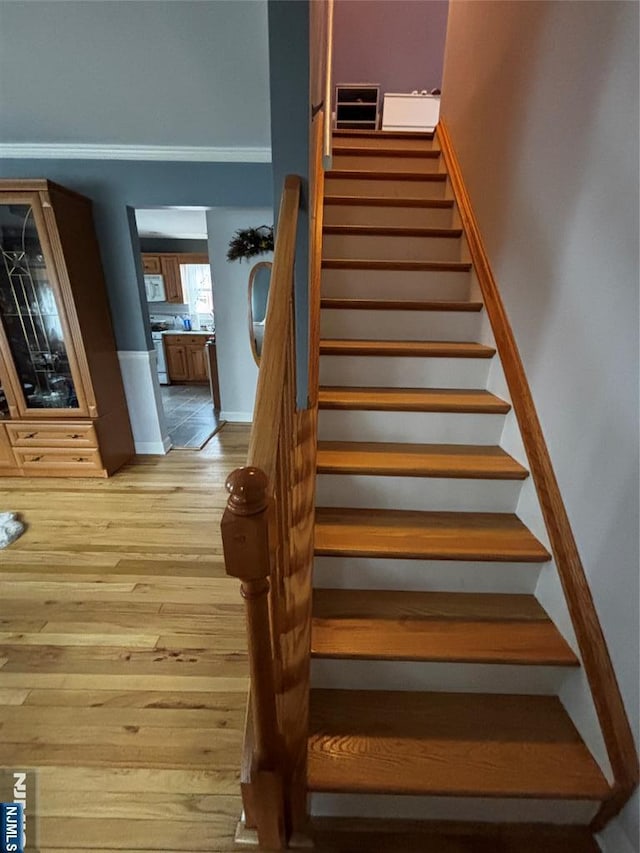 stairs featuring wood finished floors