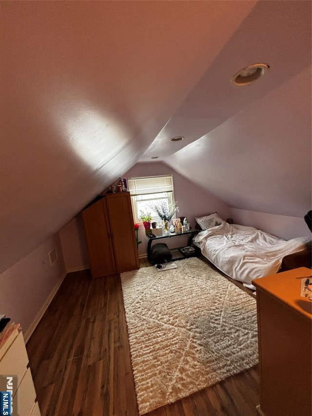 bedroom with visible vents, baseboards, vaulted ceiling, and dark wood-style floors
