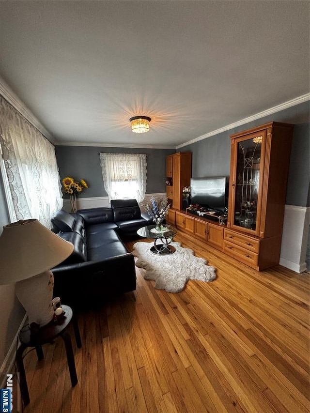 living room with light wood-style flooring and crown molding