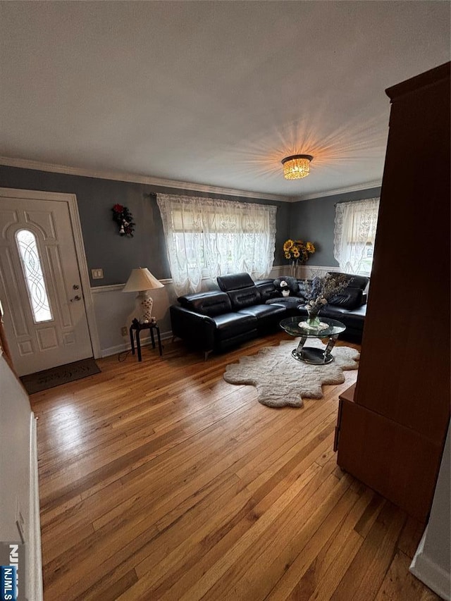 living area with crown molding and hardwood / wood-style floors