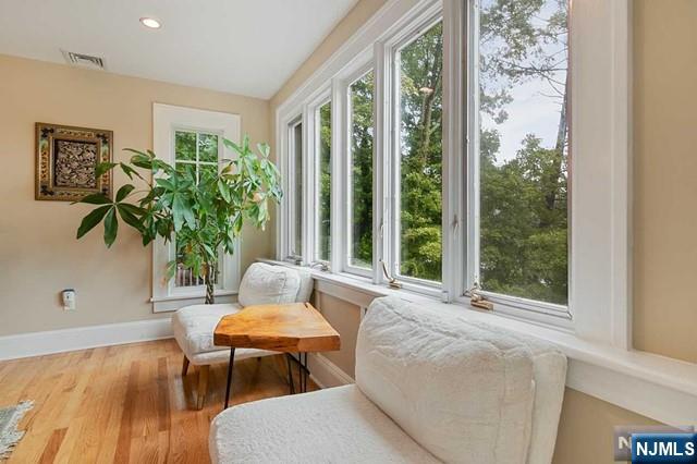 living area with visible vents, baseboards, recessed lighting, and wood finished floors