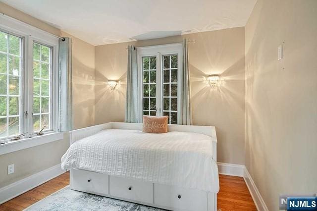 bedroom with baseboards and wood finished floors