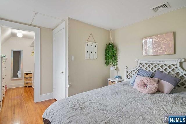 bedroom featuring light wood-style flooring, baseboards, and visible vents