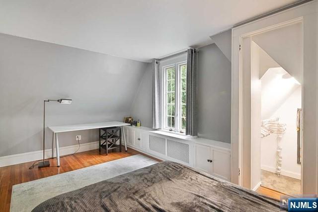office space with wood finished floors, baseboards, and lofted ceiling