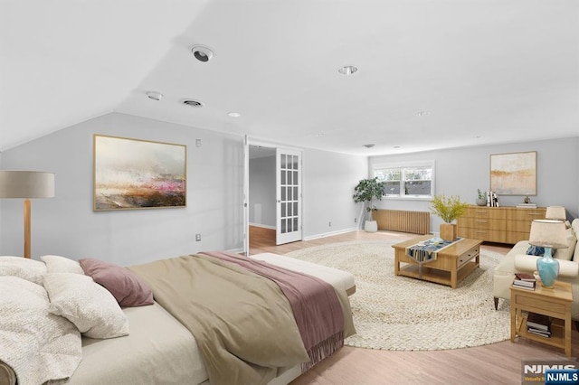 bedroom featuring radiator, vaulted ceiling, visible vents, recessed lighting, and wood finished floors