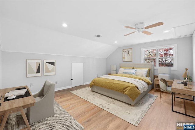 bedroom featuring visible vents, baseboards, vaulted ceiling, and wood finished floors