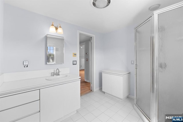 full bath featuring a shower stall, baseboards, vanity, and tile patterned floors
