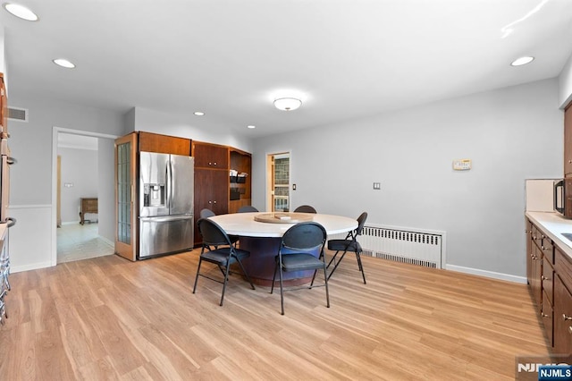 dining space with radiator, light wood-type flooring, visible vents, and recessed lighting