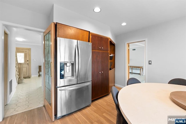 kitchen with radiator, recessed lighting, stainless steel fridge with ice dispenser, visible vents, and baseboards