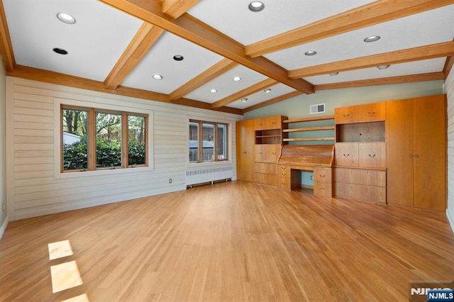 unfurnished living room with radiator heating unit, built in desk, lofted ceiling with beams, light wood-style floors, and visible vents