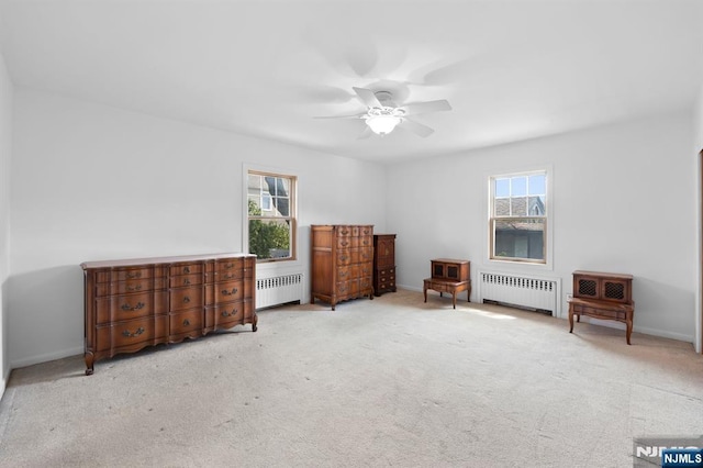 bedroom featuring radiator heating unit, multiple windows, and carpet