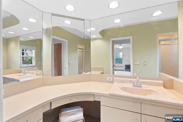 full bath with recessed lighting, a healthy amount of sunlight, and vanity