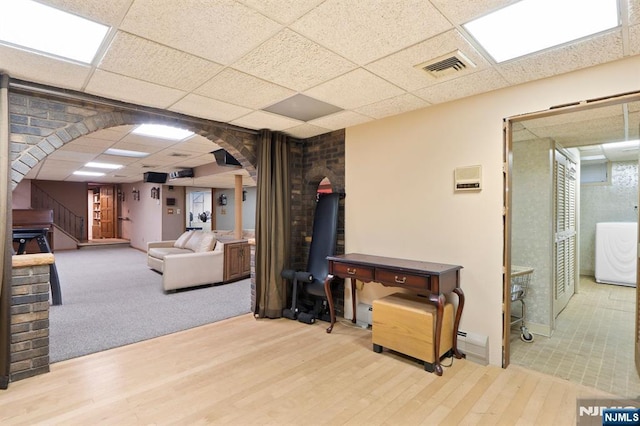 interior space with stairway, wood finished floors, washer / dryer, visible vents, and a paneled ceiling