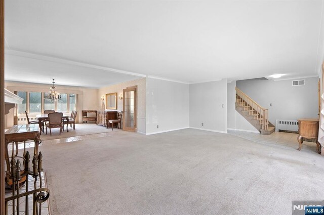 unfurnished living room featuring radiator, stairway, carpet floors, baseboards, and a chandelier