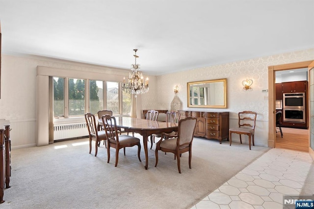 dining room with a chandelier, wallpapered walls, radiator heating unit, and light colored carpet