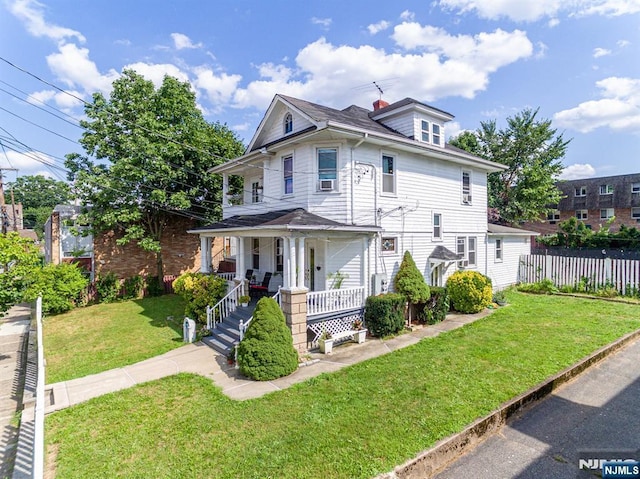 traditional style home featuring a chimney, cooling unit, a front yard, a porch, and fence