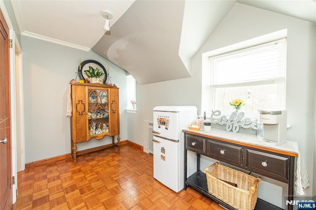 interior space with vaulted ceiling, baseboards, and crown molding