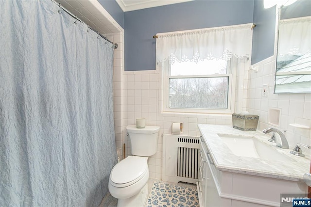 full bath with radiator heating unit, tile patterned floors, toilet, vanity, and tile walls