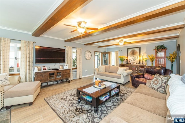 living room featuring ceiling fan, a wealth of natural light, wood finished floors, and beamed ceiling
