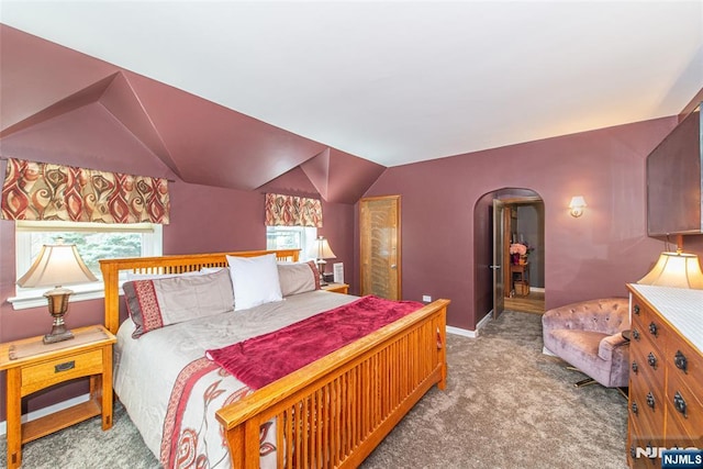 carpeted bedroom with arched walkways