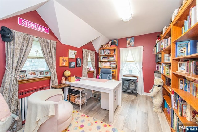 office space featuring vaulted ceiling, light wood-style floors, and baseboards
